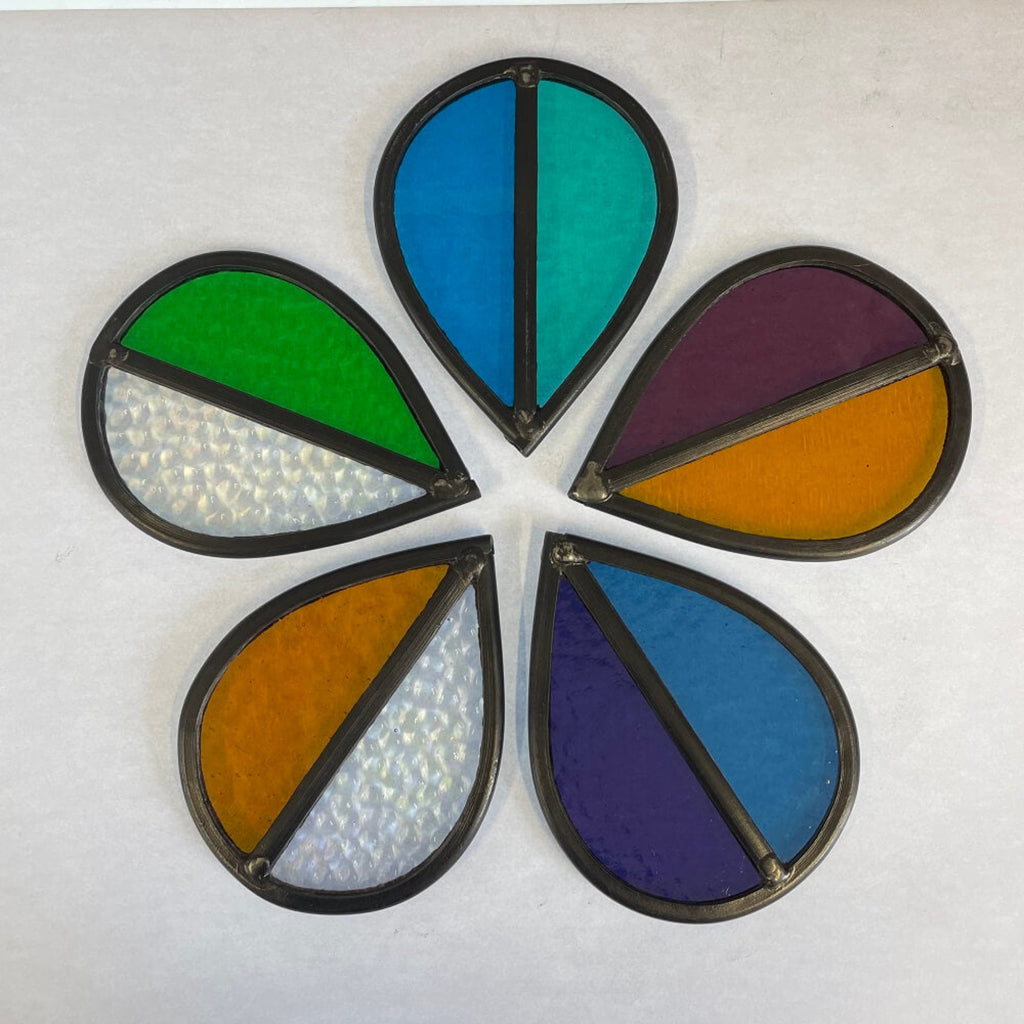 5 colourful stained glass garden tree spinners / in house sun catchers, laid flat  in a group of 5, arranged like a flower shape, on a white background., purple, orange, aqua, blue, green, violet stained glass.