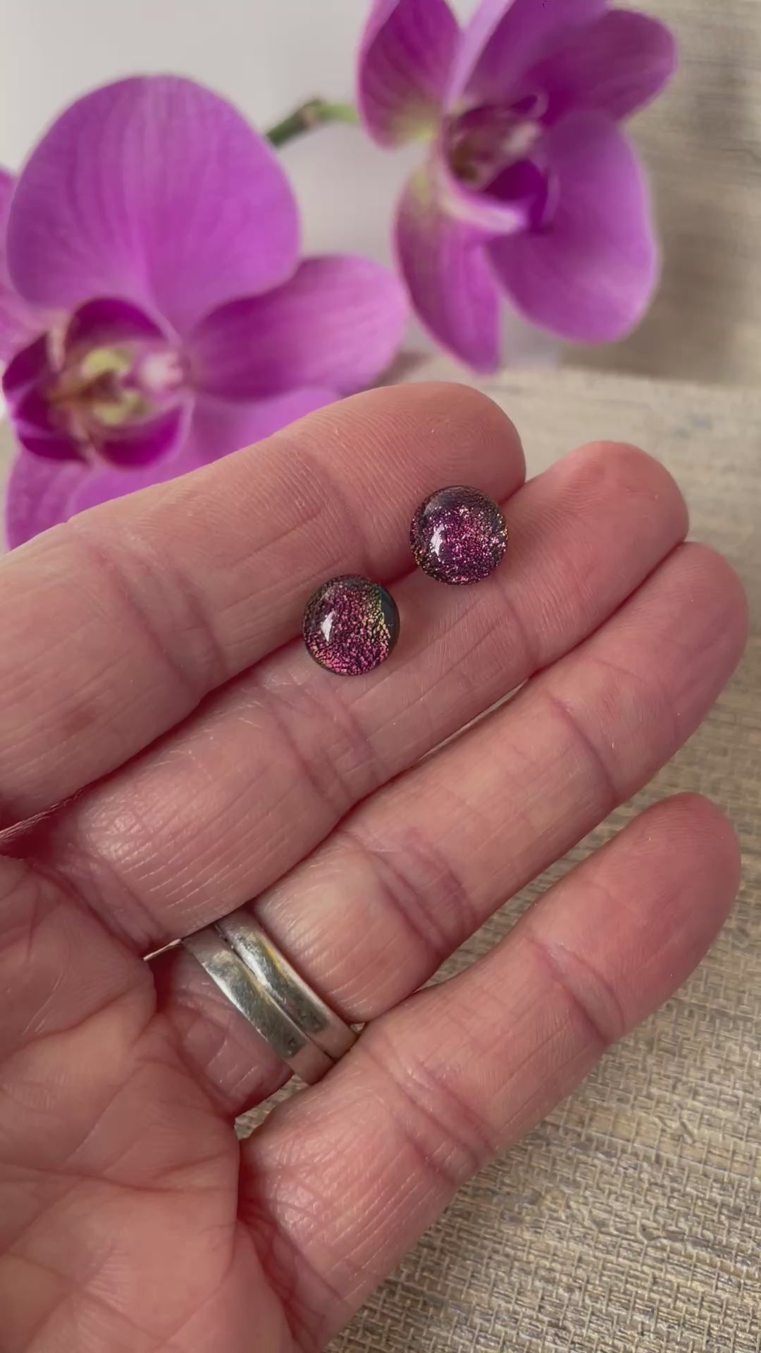 pink glittery fused glass studs, dichroic fused glass, video of hand moving them back and forth